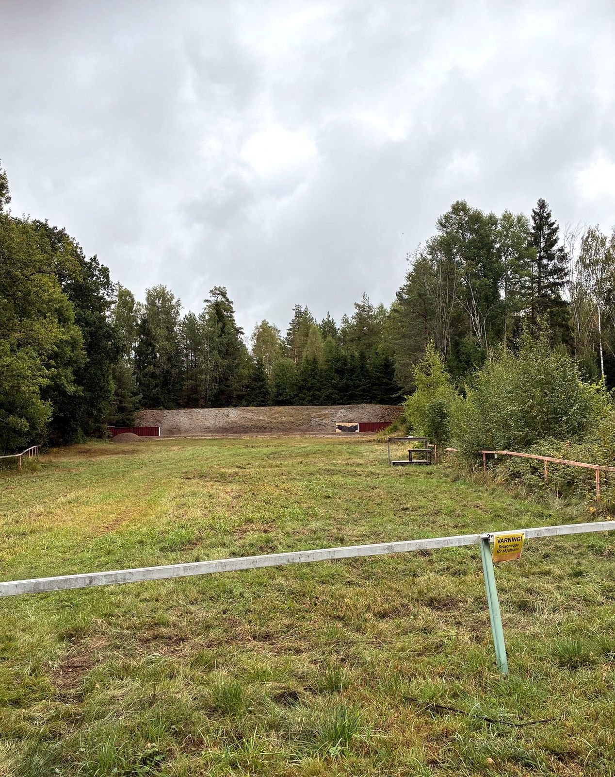 Älgbanan med löparställ, varningsskylt och kulfångsvall i bakgrunden.