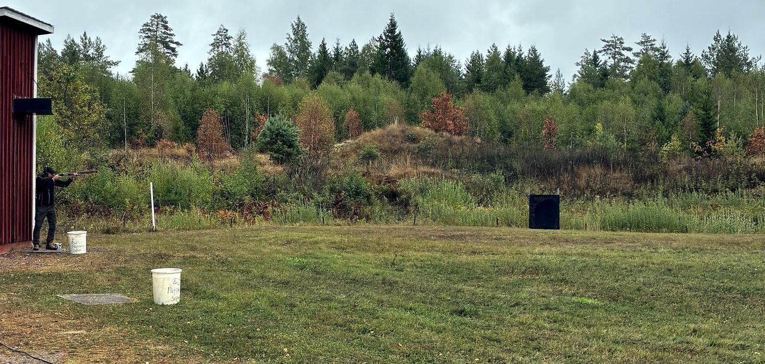 Skytt vid skjuthytten som siktar mot måltavlan på skjutbanan.